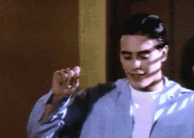 a man wearing a blue jacket and a white shirt is dancing .