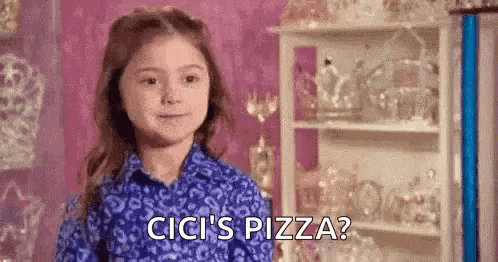 a little girl in a blue shirt is standing in front of a shelf and saying `` cici 's pizza ? ''