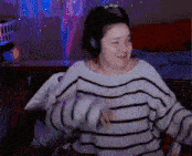 a woman wearing a striped sweater and headphones is dancing