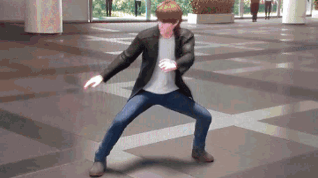 a man in a black jacket and blue jeans is standing on one leg
