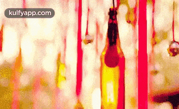 a bottle of beer is hanging from a rope in a blurry photo .