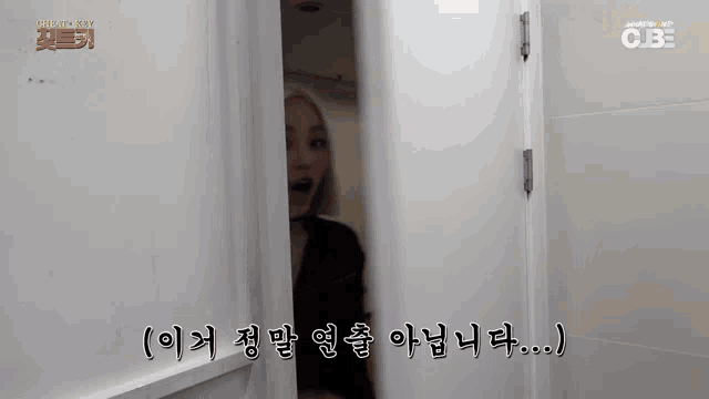a woman is standing in a doorway with her mouth open .