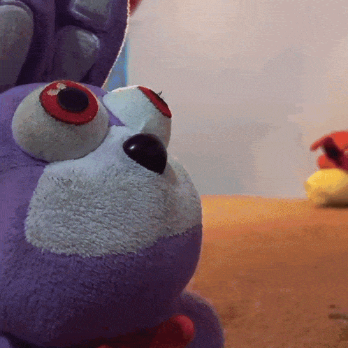 a close up of a stuffed animal 's face with red eyes