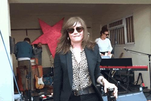 a woman in sunglasses stands in front of a ro3 keyboard