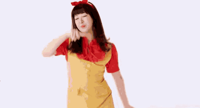 the girl is wearing a yellow dress and a red shirt and is dancing .