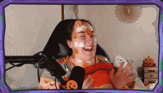 a woman with halloween stickers on her face is laughing
