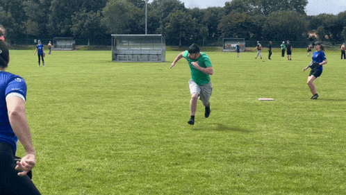 a man in a green shirt running on a field