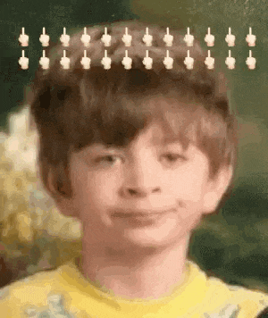 a young boy with a bunch of middle fingers in his hair is making a funny face .