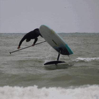 a man is riding a surfboard in the ocean with a yellow sticker on it that says ' foil ' on it