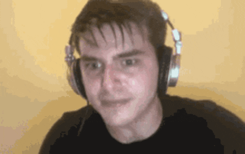a man is wearing headphones and making a face