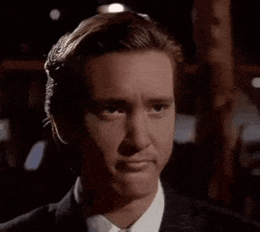 a man in a suit and tie is smiling at the camera .