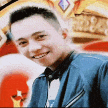 a young man in a blue jacket is smiling in front of a crown .