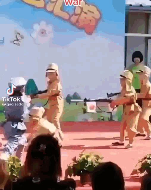 a group of children are dressed in military uniforms and holding guns on a stage .