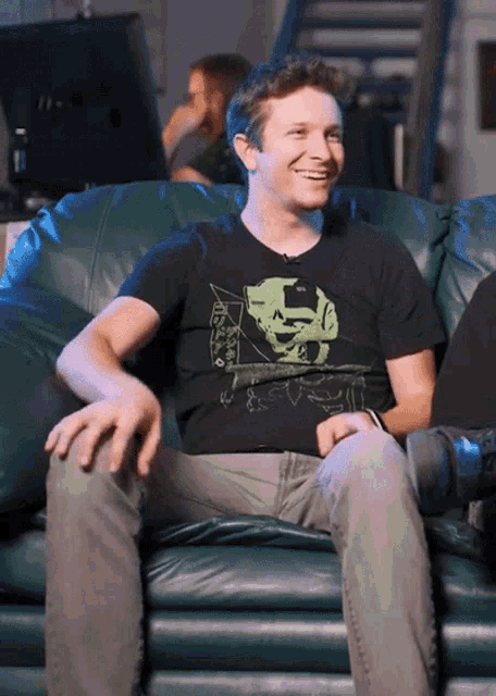 a man wearing a black shirt with a green skull on it