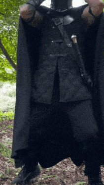 a man wearing a black cape and a black helmet