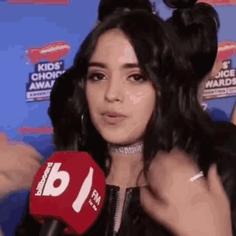 a girl is talking into a billboard microphone
