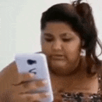 a fat woman is looking at her cell phone .
