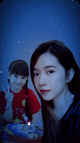 a girl in a red shirt is giving a peace sign next to a woman