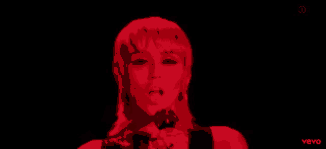 a close up of a woman 's face with a red light behind her