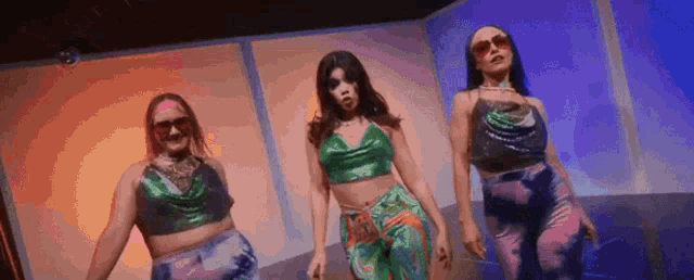 three women are dancing together on a stage in a room .
