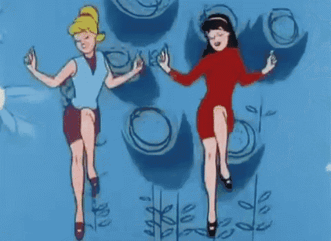 two cartoon girls are dancing in front of a blue wall with circles on it .