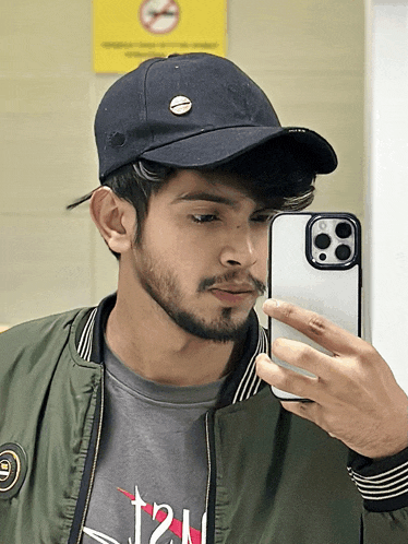 a man taking a picture of himself in a mirror with a hat on