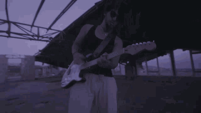 a man wearing sunglasses is playing a guitar