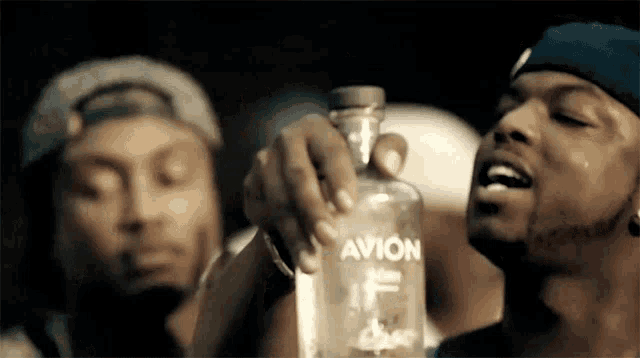 a man holding a bottle of avion vodka