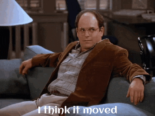 a man sitting on a couch with the words " i think it moved " on the bottom