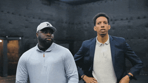 a man wearing a hurley hat is standing next to another man