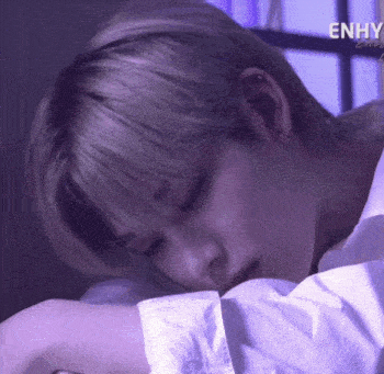 a close up of a person sleeping on a bed with their head on their arm .