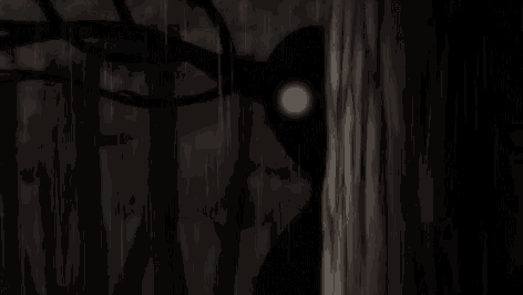a silhouette of a person standing next to a tree with a light coming out of it 's eyes .