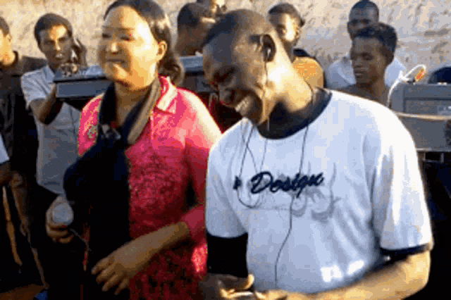 a man wearing a shirt that says desigual laughs with a woman