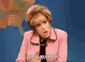 a woman in a pink jacket and tie is standing in front of a map of the united states and talking .