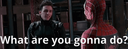 a man in a spiderman suit is talking to another man in a leather jacket .