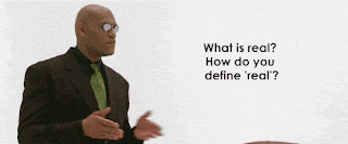 a man in a suit and tie is asking what is real how do you define real