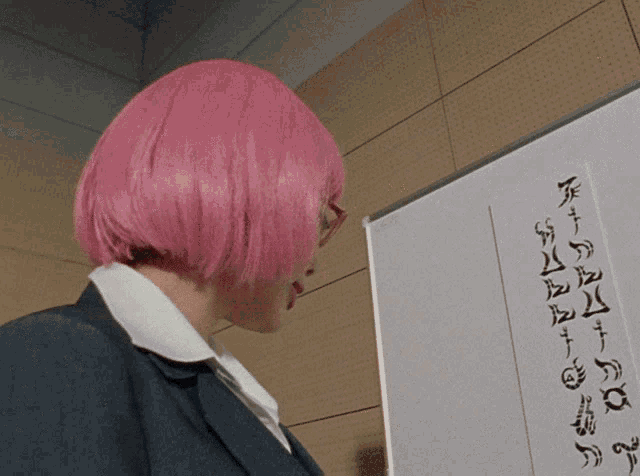 a woman with pink hair is looking at a whiteboard with chinese writing on it