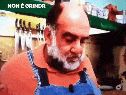 a bald man with a beard wearing overalls and an orange shirt is standing in front of a shelf with knives .