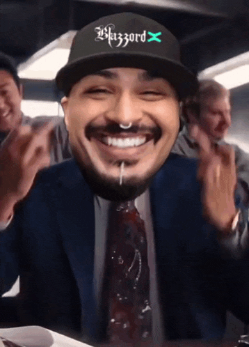 a man wearing a hat that says blizzard x is smiling