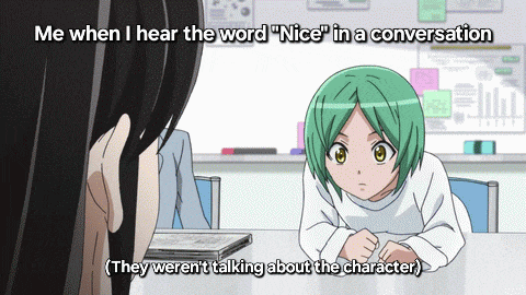 a girl with green hair is sitting at a table and talking to another girl with black hair