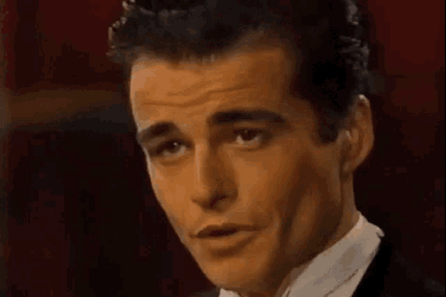 a man in a tuxedo and white shirt is making a funny face