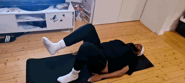 a person is laying on a yoga mat with their feet up