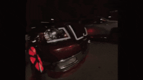 a car wheel with purple lights on it is driving down the road at night .