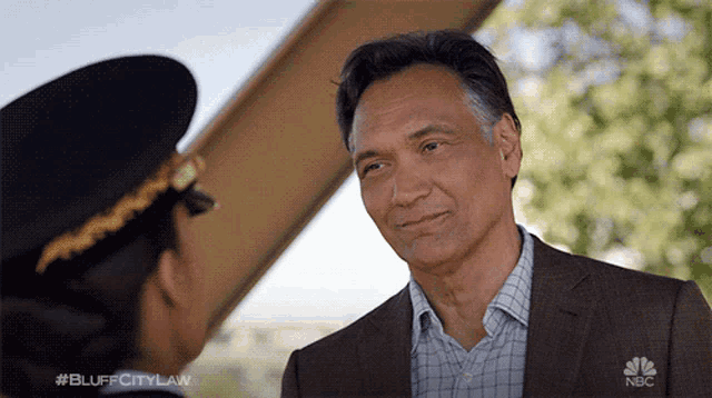 a man in a suit is talking to a woman in a pilot hat with the hashtag #bluffcitylaw on the bottom