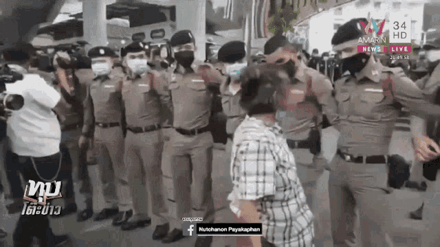 a group of police officers wearing face masks are standing in front of a woman