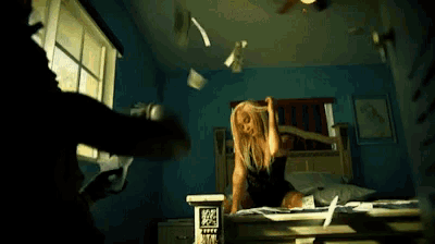 a woman in a black dress is standing on a bed with papers falling from the ceiling