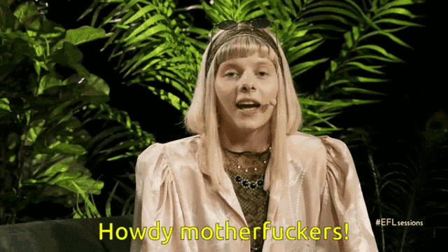 a woman says howdy motherfuckers while sitting on a green couch