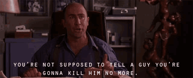 a man sitting at a desk with the words " you 're not supposed to tell a guy you