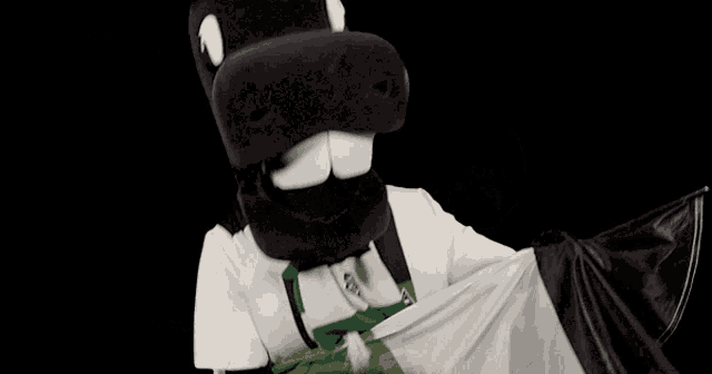 a black and white horse mascot is holding a green and black flag