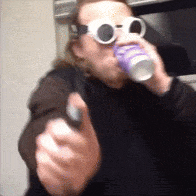 a man wearing sunglasses is drinking from a cup